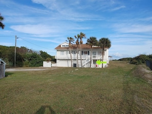 A two-story house with a front porch, a garage, and a fenced yard.