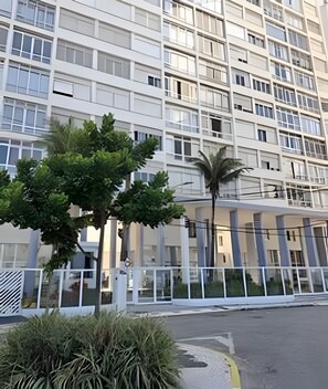 Un edificio de varios pisos con un diseño arquitectónico moderno, que cuenta con una serie de balcones y ventanas amplias.