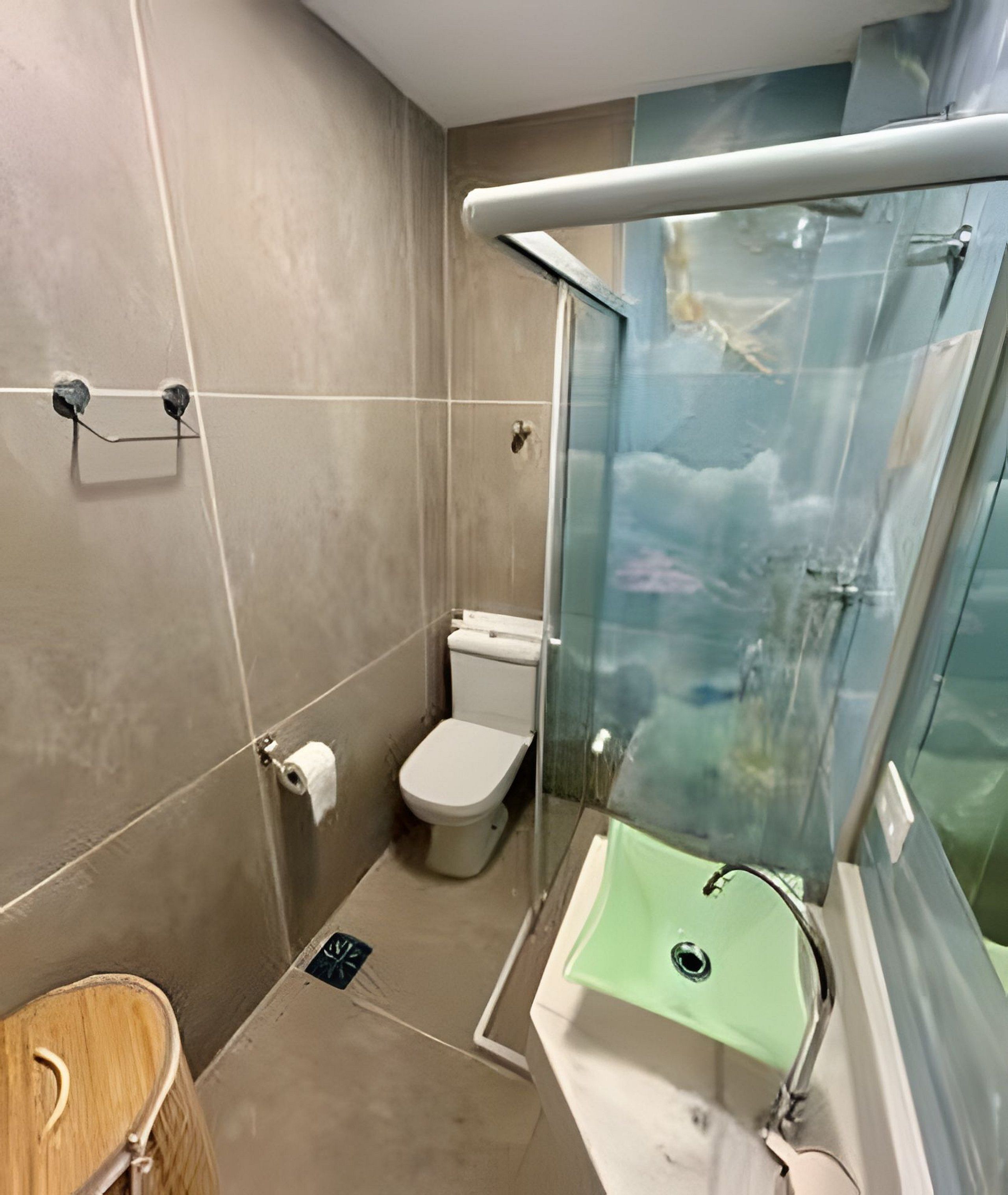 Un bagno moderno con box doccia in vetro, un water e un lavabo.