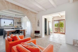 A spacious living area with a modern kitchen, a dining area, and a large sliding glass door leading to an outdoor patio.