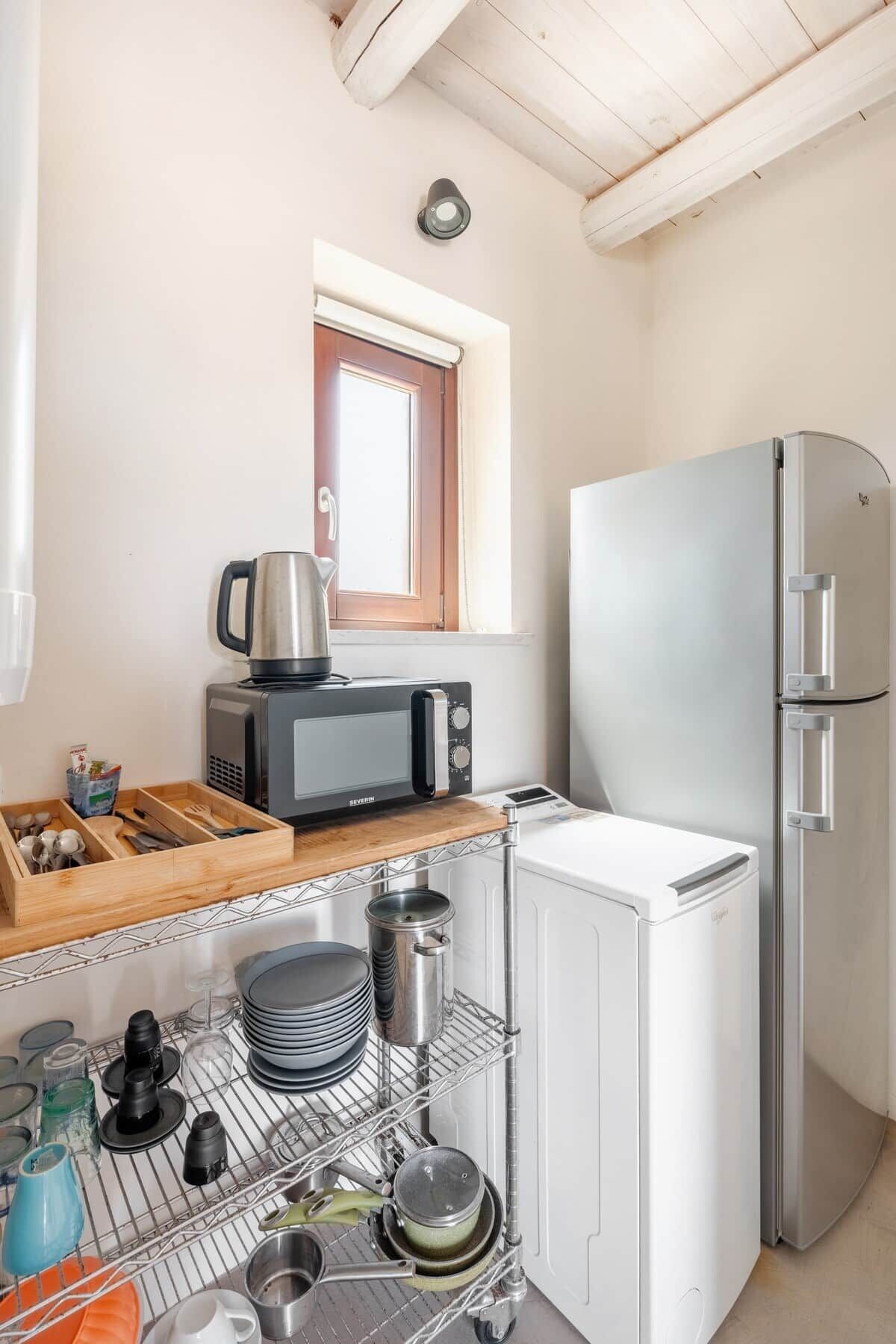 Eine kleine Küche mit Mikrowelle, Toaster und Kühlschrank.