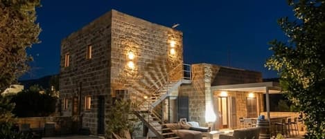 Un edificio de piedra con una escalera que conduce a un espacio al aire libre techado.