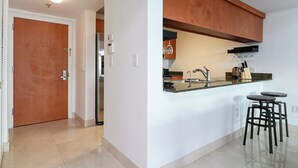 Une cuisine moderne équipée d’un réfrigérateur encastré, d’un évier et de tabourets de bar.