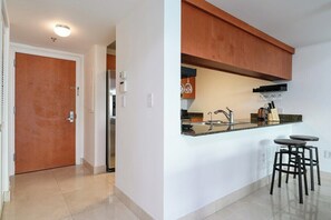 Eine moderne Küche mit einem eingebauten Kühlschrank, einer Spüle und Barhocker.