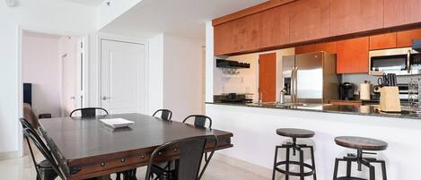 A modern kitchen with a central island, stainless steel appliances, and wooden cabinetry.