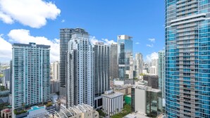 Un quartier urbain dense, caractérisé par de nombreux immeubles de grande hauteur et des bâtiments modernes, dont un gratte-ciel remarquable avec une façade en verre.