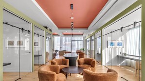 A modern office space with glass walls, a round table, and comfortable seating. - 4BR/4BA 2-Unit Combo for 12 · Rooftop Pool + Views (Miami)