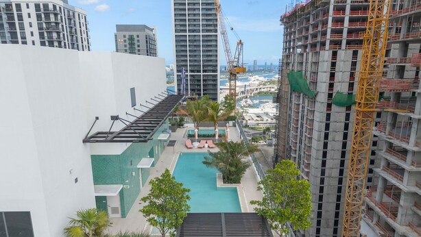 A rooftop pool area with a view of the marina and surrounding buildings. - 4BR/4BA 2-Unit Combo for 12 · Rooftop Pool + Views (Miami)