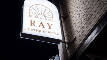 Hotellin kyltti, jossa lukee »RAY BOUTIQUE HOTEL» ja on aurinkoa muistuttava logo.