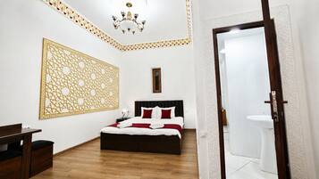 Une chambre d’hôtel avec un lit, une table de chevet et un grand élément décoratif mural.