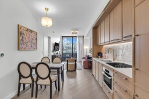A modern kitchen with wooden cabinets, a marble countertop, and a built-in oven. - 2 Units on One Floor for 8 · Wynwood Rooftop Pool (Miami)