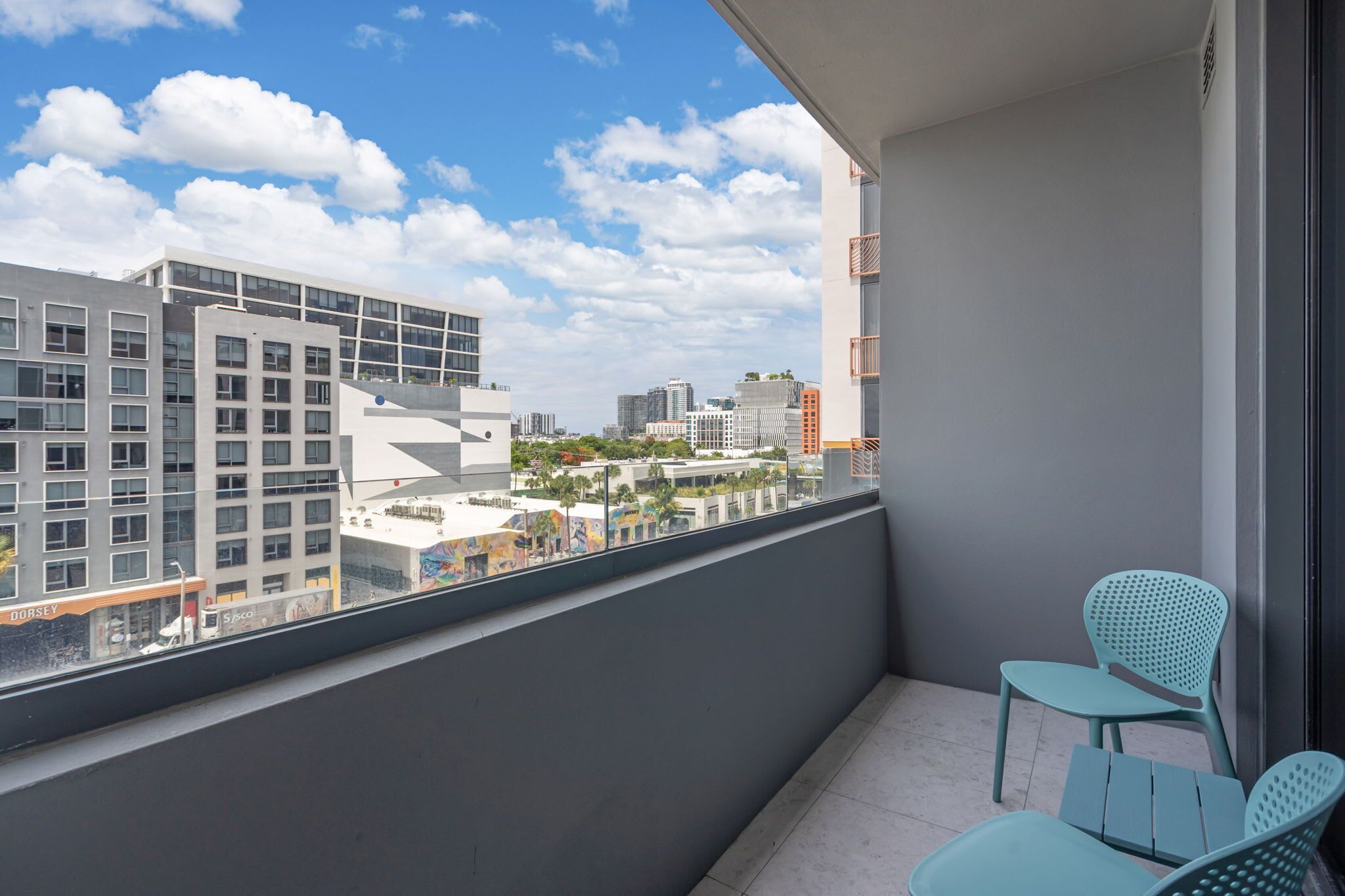 Un balcon donnant sur un paysage urbain, une chaise et une petite table.