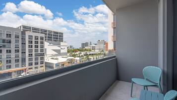 Un balcon donnant sur un paysage urbain, une chaise et une petite table.