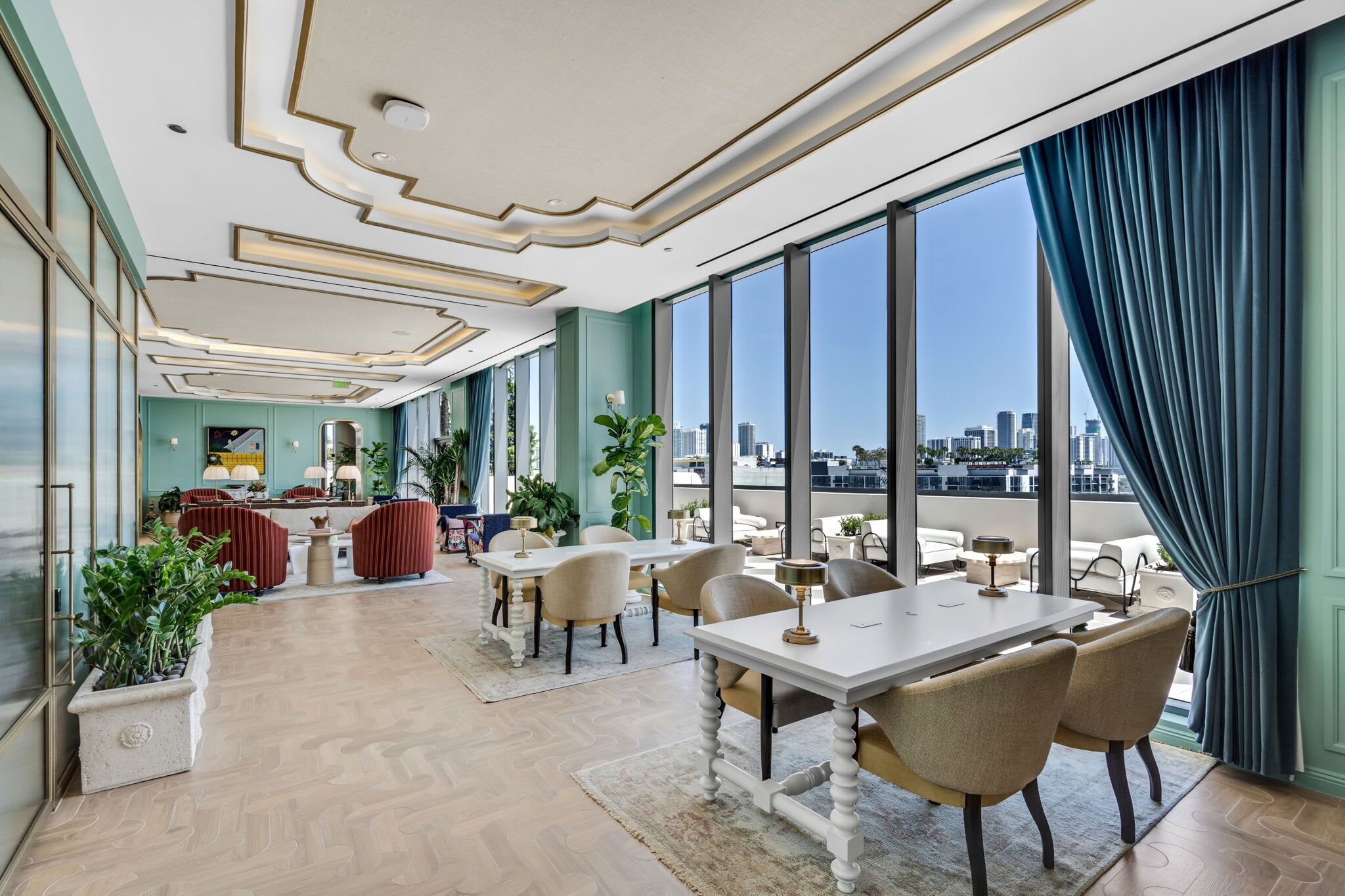 Une salle à manger spacieuse, dotée d’un haut plafond et de grandes fenêtres offrant une vue sur la ville.