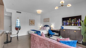 Een moderne woonkamer met een bank, een eettafel en een schilderij van een stadsgezicht.