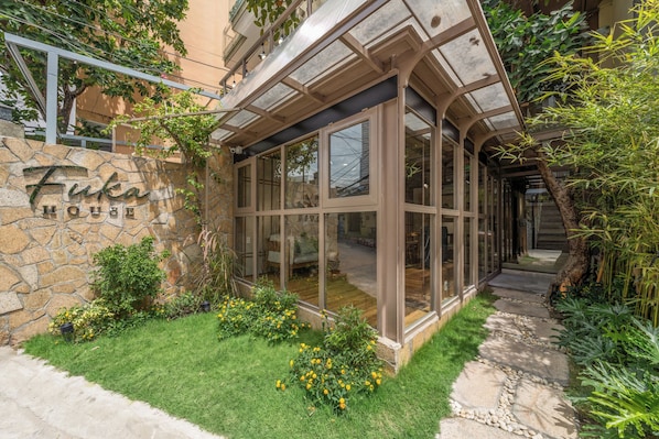 A house with a stone facade and a glass conservatory.