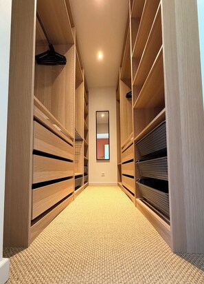 A narrow hallway with wooden shelving units on both sides, leading to a door at the end. - A peaceful retreat with a pool and a view of the countryside (Preignan)