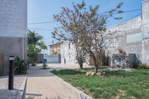 A paved pathway leading to a building with a white facade, surrounded by greenery and a small tree. - Memories - Local Lodging (Nogueira da Regedoura)