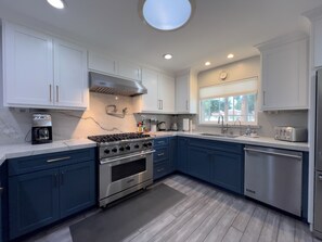A modern kitchen with white cabinets, a stainless steel stove, and a dishwasher. - Beautiful 4-bedroom house with AC in Hollister (Hollister)