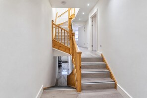 A staircase with wooden handrails and light-colored steps leading to an upper floor. - Cardiff 5-bed House, Sleeps 13 w/ Parking & Garden (Cardiff)