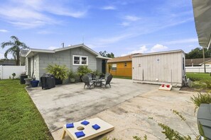 A residential backyard with a patio, outdoor seating, a shed, and a lawn. - 2 bed 2 bath Home Close to Downtown and Stadiums (Tampa)