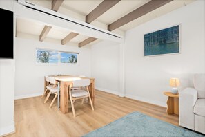 A modern interior with a wooden dining table and chairs, a painting on the wall, and a lamp on a side table. - Waterfront Retreat w/ Dock, Hot Tub & Views (Bethel Island)