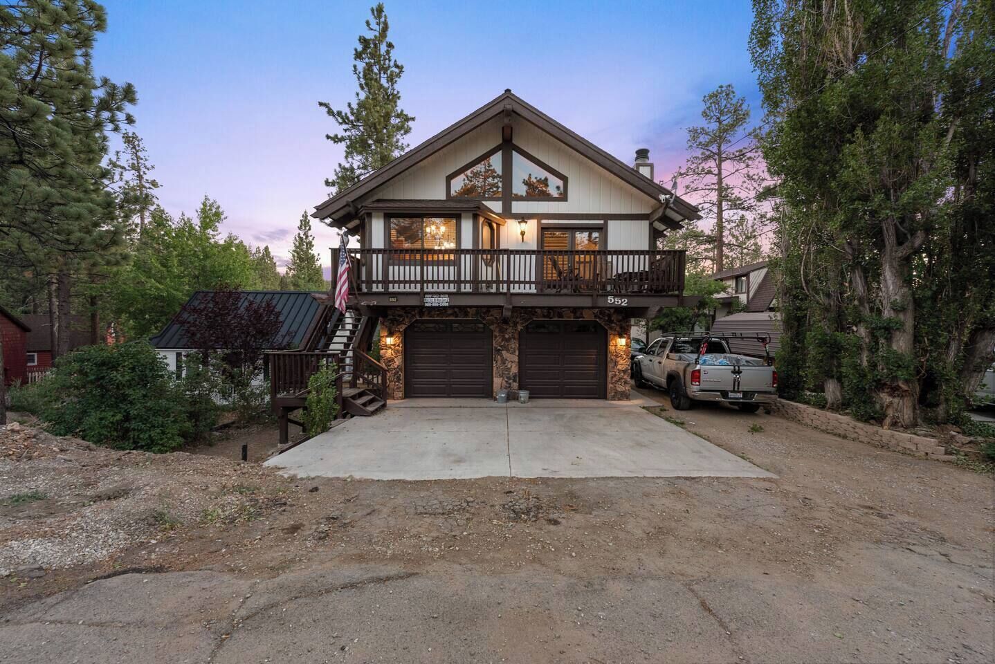 A two-story house with a balcony, a garage, and a driveway.