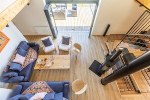 A modern interior with a wooden floor, a sofa, a coffee table, and a staircase.