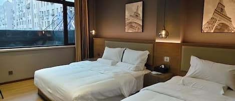 Habitación de hotel con dos camas, un ventanal con vistas a edificios y una obra de arte de la Torre Eiffel.