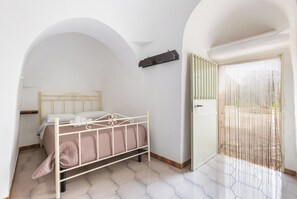 Ein Schlafzimmer mit einem Bett, einem Kleiderschrank und einem Balkon mit einem Insektenschutznetz.