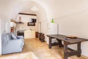 A compact kitchen with a stove, sink, and white refrigerator. - Trullo Sardella by BarbarHouse (Ceglie Messapica)