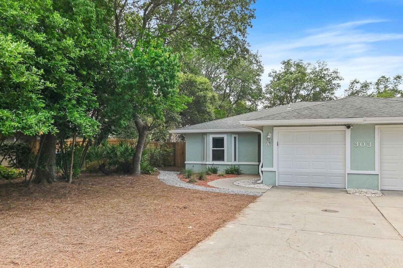 A single-story house with a garage, a driveway, and a well-maintained lawn.