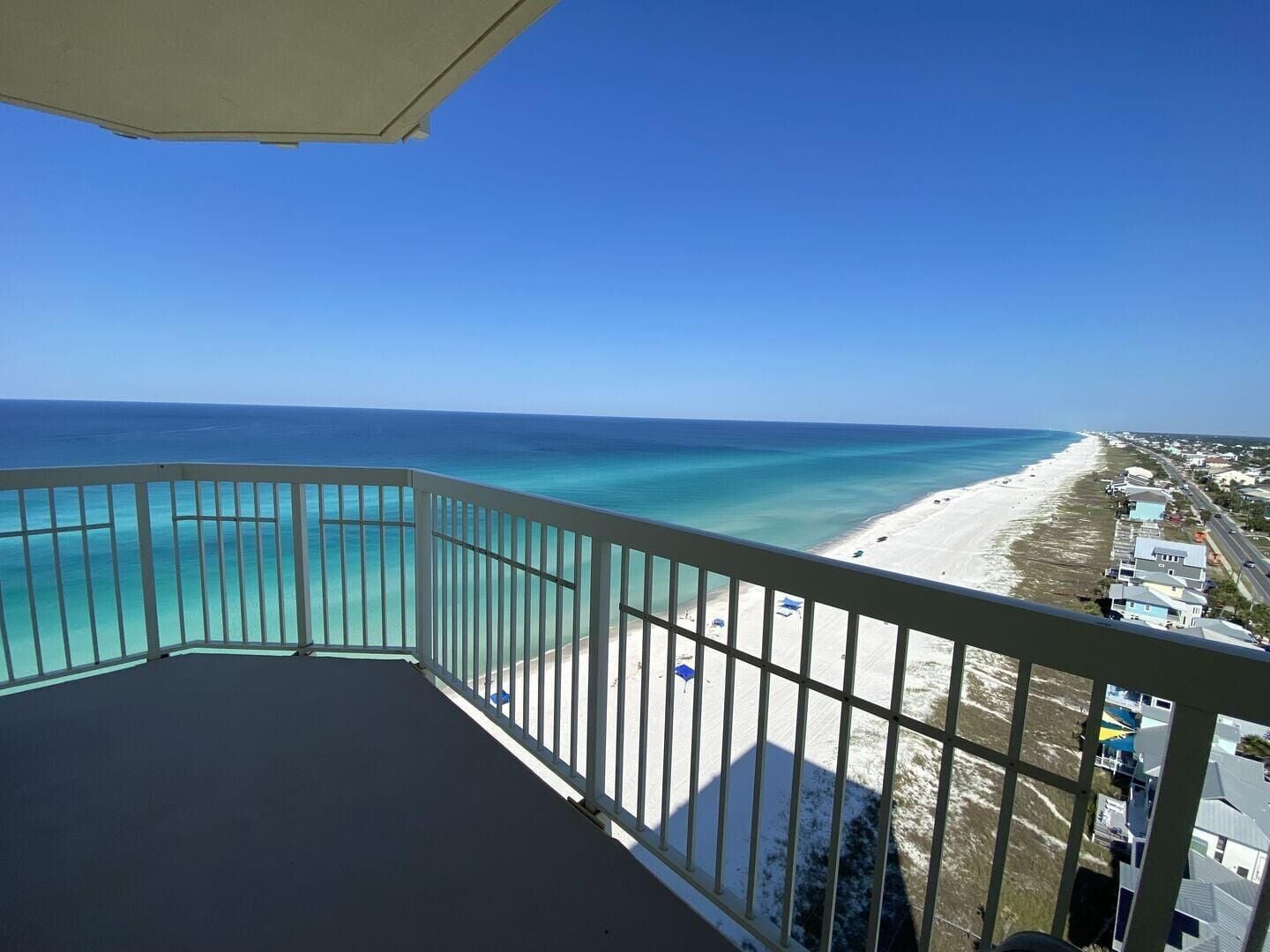 Een balkon met uitzicht op een strand en zee.