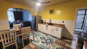 A compact living space with a dining area, kitchenette, and a ceiling fan. - Ale Air Guest House. Enjoy a stylish experience right in downtown Shamokin. (Shamokin)