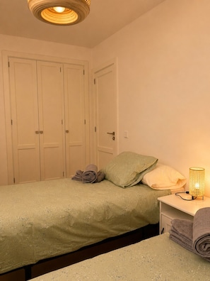 A bedroom with a bed, a nightstand, a lamp, and a closet. - BEAUTIFUL DUPLEX WITH A TERRACE IN COSTA TEGUISE (Costa Teguise)