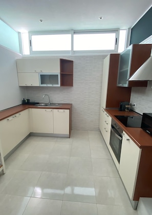 A modern kitchen with white cabinetry, a stainless steel sink, and a built-in oven. - BEAUTIFUL DUPLEX WITH A TERRACE IN COSTA TEGUISE (Costa Teguise)