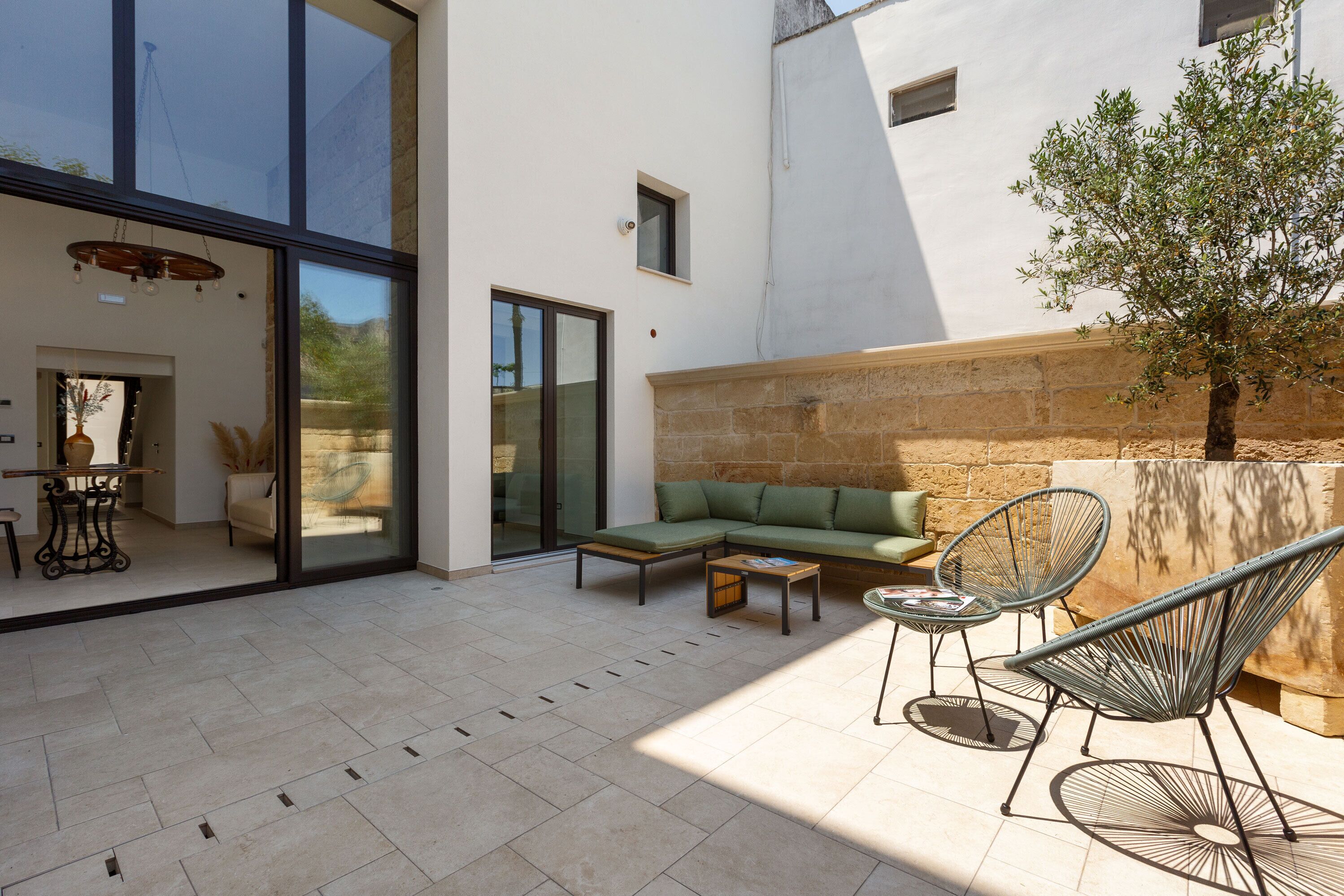 Un espacio al aire libre moderno con sofá, sillones y una mesa.