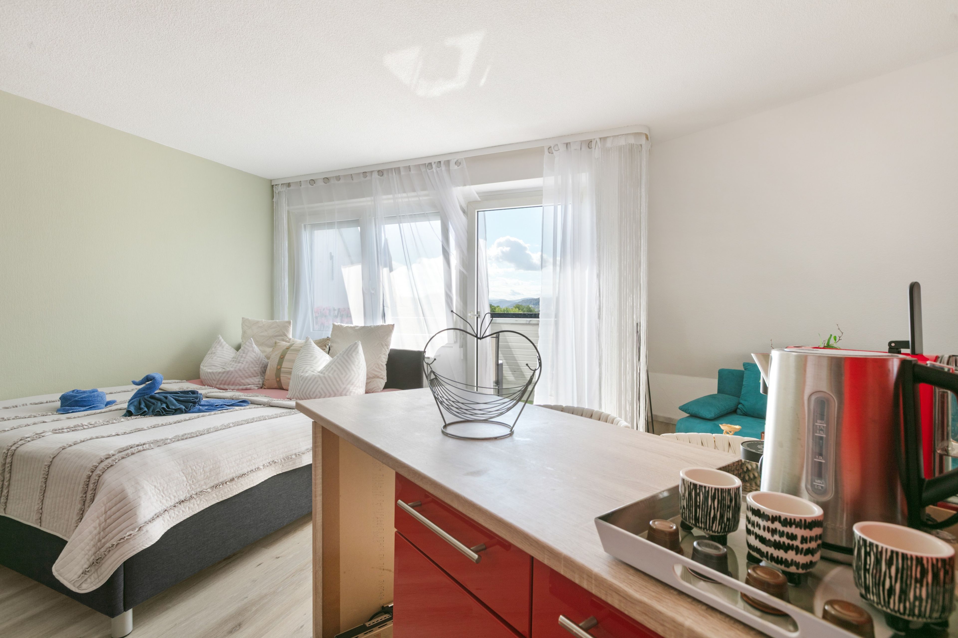 Habitación de hotel moderna con cama, escritorio, silla y vistas al exterior.