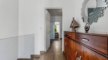 Un pasillo con un aparador de madera y un espejo en la pared.