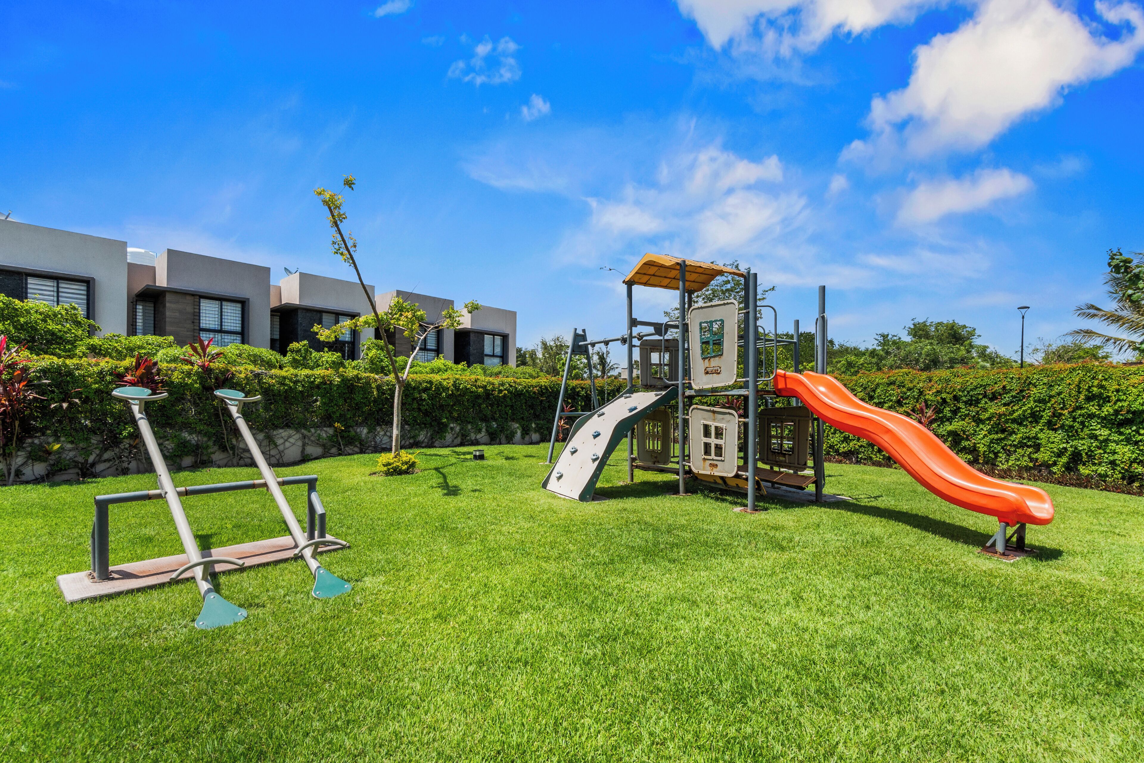 A playground with a slide, climbing structure, and exercise equipment.