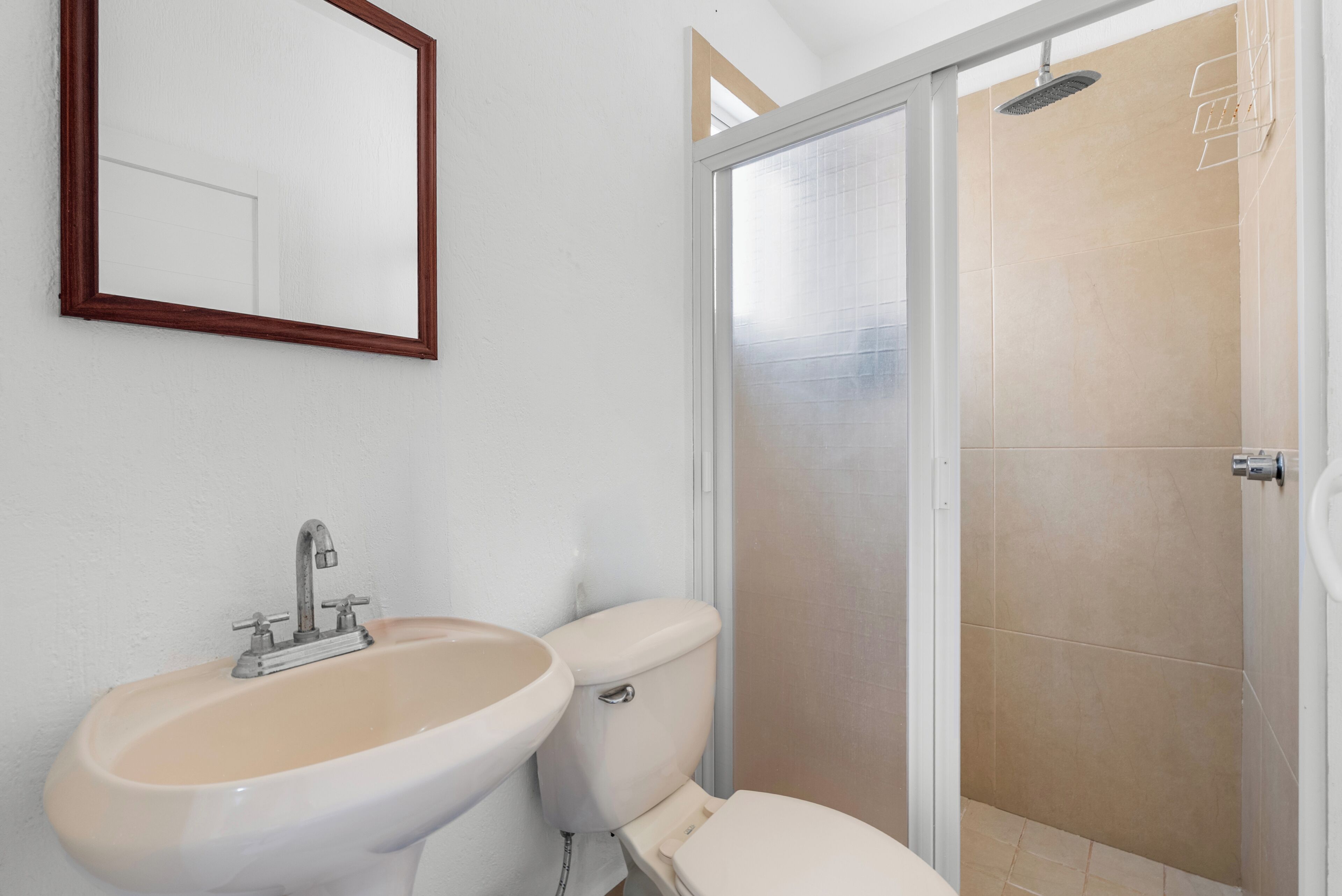 Un baño con lavamanos, inodoro y ducha.