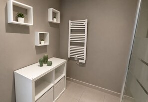 A bathroom with a white vanity, a towel rack, and three potted plants on the wall. - Résidence Cœur Marin : T2 climatisé avec terrasse et parking proche plage (Le Grau-du-Roi)