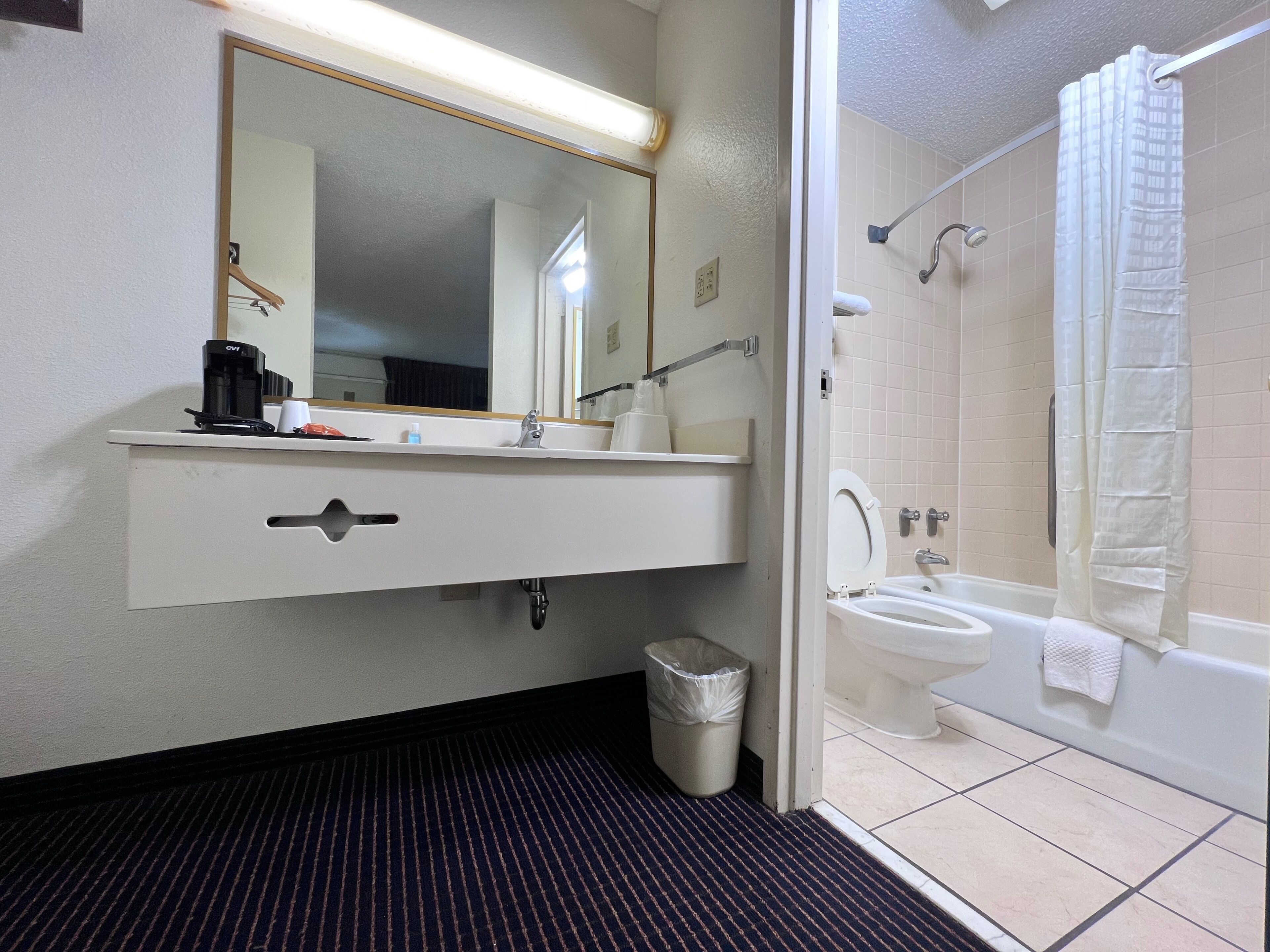 A bathroom with a sink, mirror, and toilet.