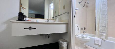 A bathroom with a sink, mirror, and toilet.