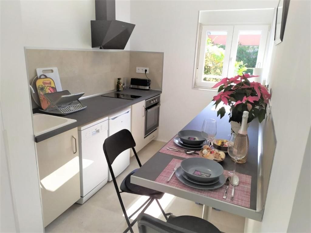 A compact kitchen with a dining area, equipped with a microwave, toaster, and a small oven.
