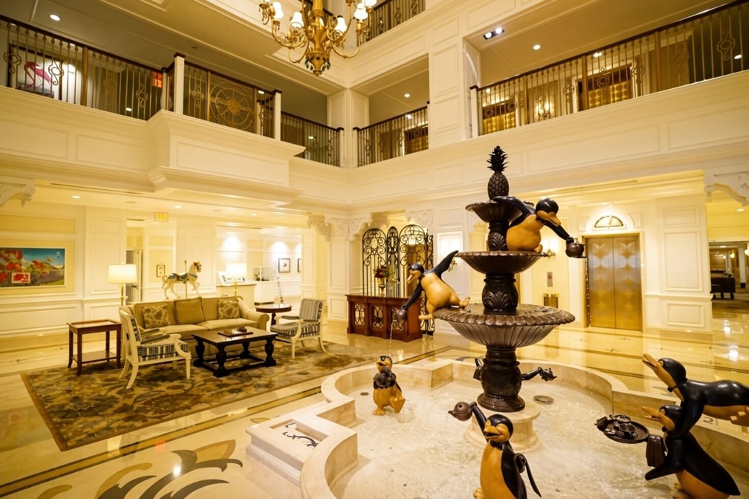 Un hall d’hôtel à plusieurs niveaux, doté d’une fontaine centrale, de coins salon et d’un lustre.