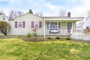 A single-story house with a front porch, a small front yard, and a white picket fence. - Quiet Ranch Retreat, Close to Everything with Outdoor Bar & Field Views (Boardman)