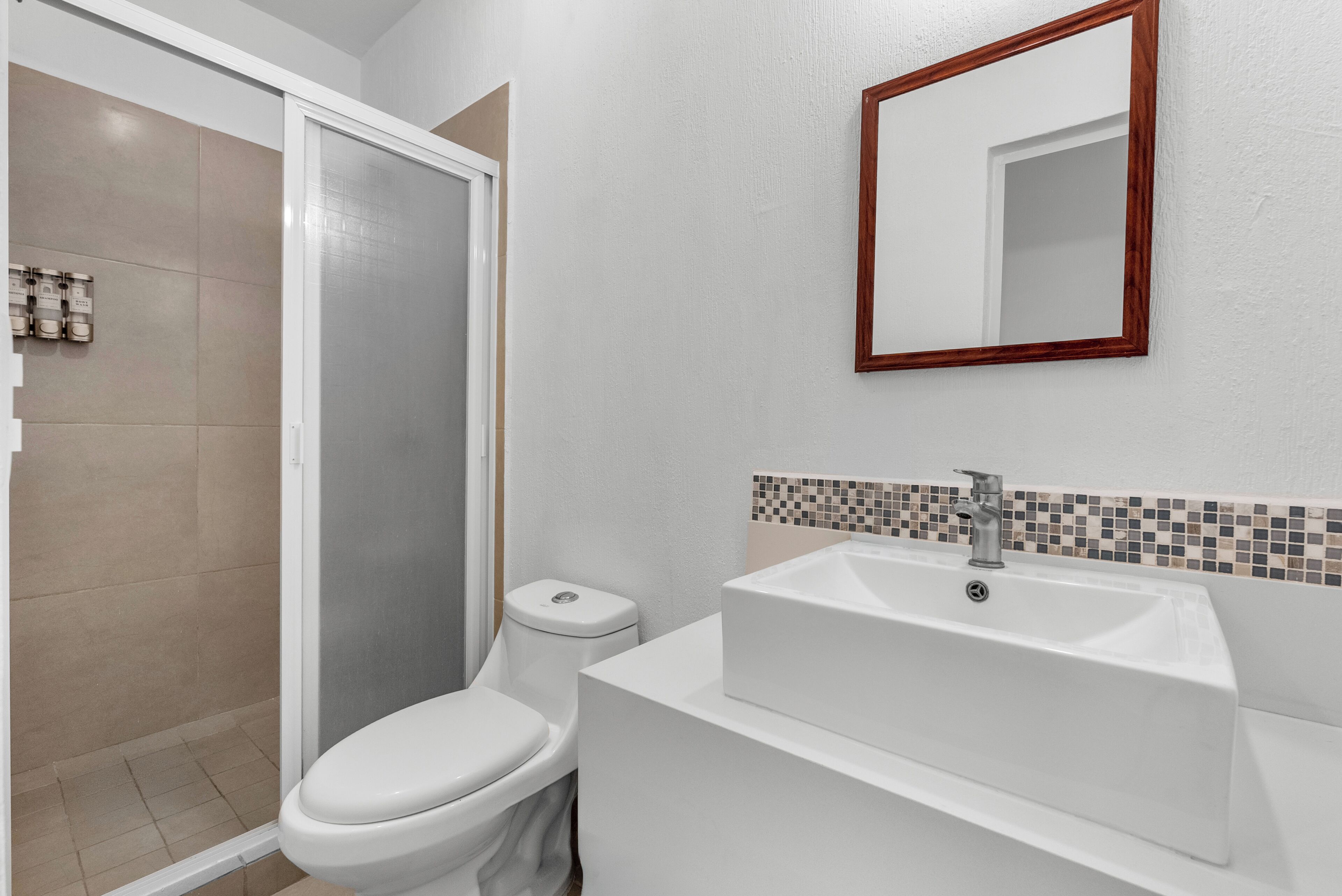 Une salle de bain avec des toilettes, une douche et un lavabo.