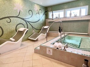 A spa area with two reclining chairs, a hot tub, and a tiled floor. - Orlando | Elegant Short Stay | Pool + Spa (Lake Buena Vista)