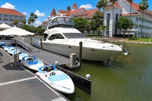 A marina with a row of small boats docked alongside a larger yacht. - Orlando | Elegant Short Stay | Pool + Spa (Lake Buena Vista)